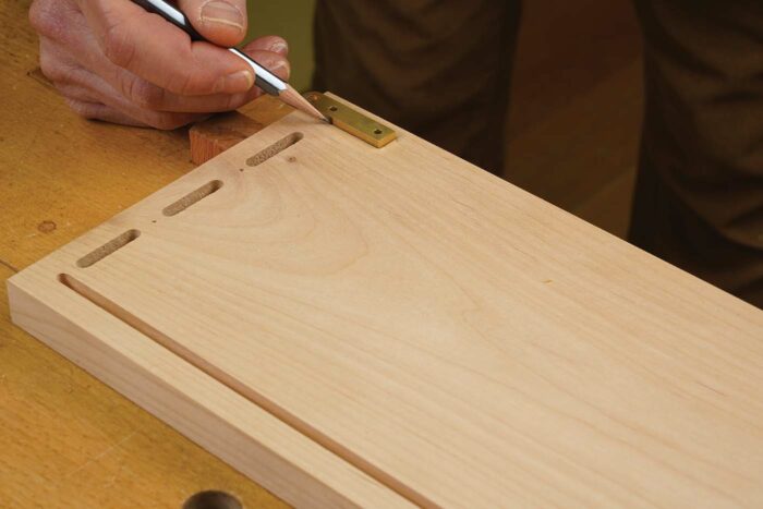 Locate the template. After disassembling the case, trace around the hinge with a sharp pencil and remove it. The fine pencil lines make it easy to align the template precisely. Shift the hinge opening until all four pencil lines disappear, and it will be in the perfect spot.