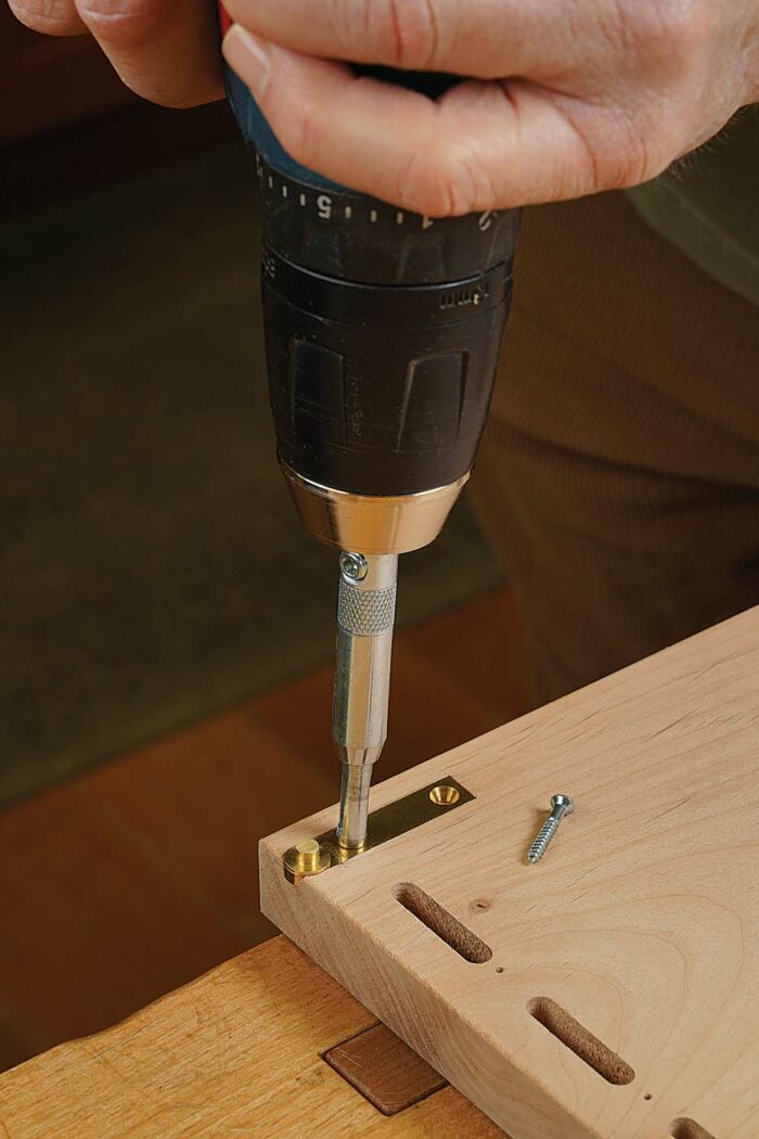 Square the corners with a chisel, check the fit, and use a self-centering bit to drill pilot holes. Then repeat all of these steps on the case top.