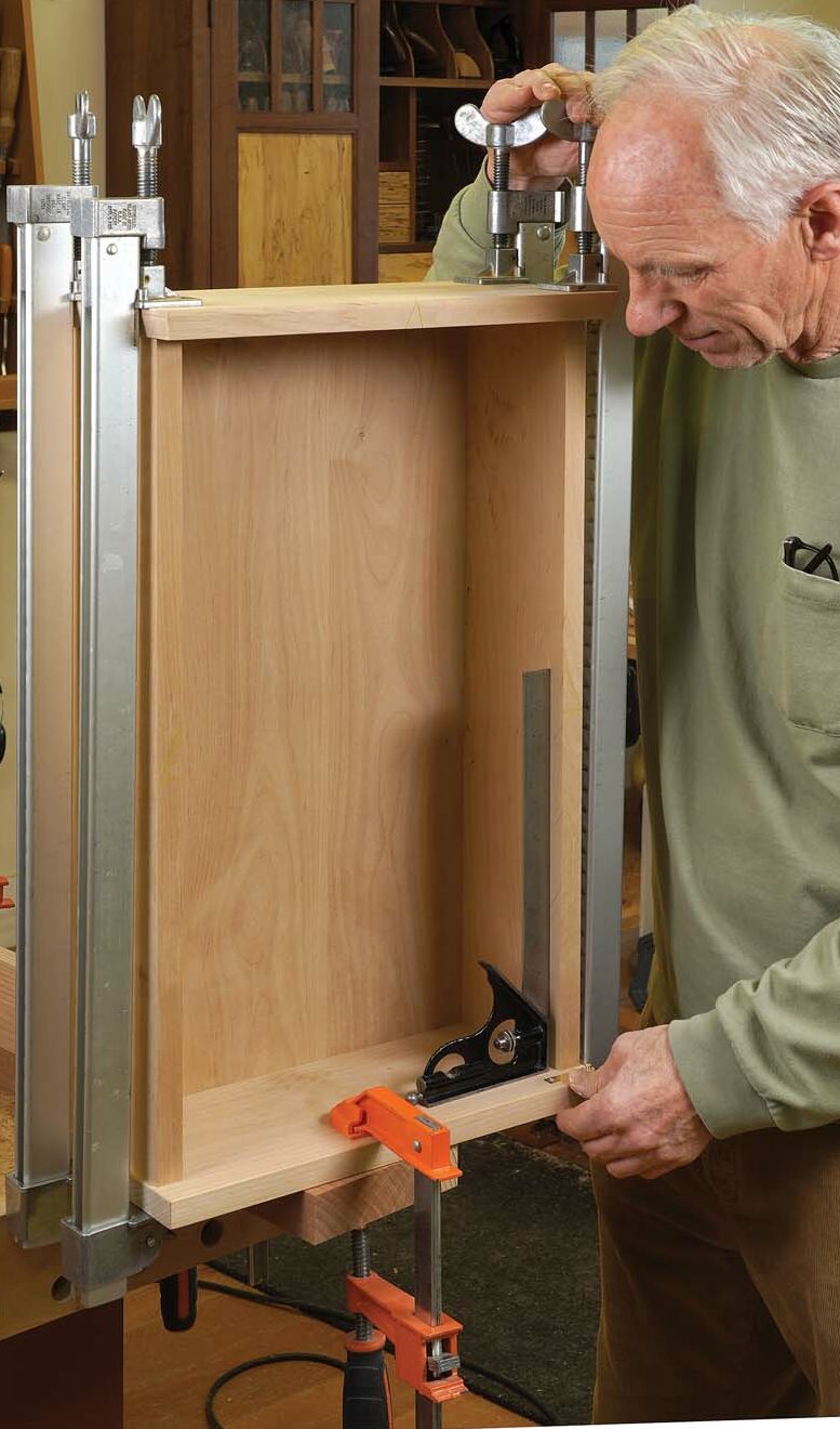 Assemble the case. With the hinge mortises cut in the top and bottom of the case, you can finally glue it up. To make it easier to fit the door, keep the case as square as possible as you clamp it.