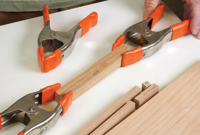 Using clamps to hold to pieces of glued wood together